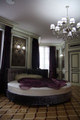 Элитная итальянская кровать в спальне, коллекционные люстра и светильники.