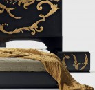 Черная кровать с золотистой росписью в изголовье