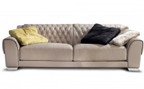 Кожаный диван со стегаными накидками на спинке и подлокотниках