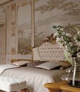 Декорированная спальня кремового оттенка с камином и встроенными
